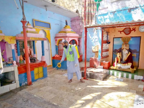 Alkhidmat volunteer disinfecting a mandir